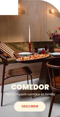 Mesa de comedor puesta con platos, vasos, velas y un ramo de flores en un ambiente acogedor